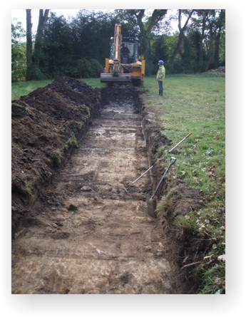 A mechanical digger opening a trench during an archaeological evaluation