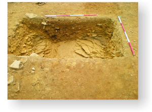 Excavation of a section across the enclosure ditch showing its rock-cut base.